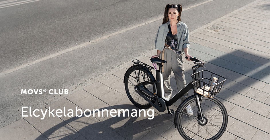 Ung kvinna med cykel, med asfalt och trottoar bakom, bild tagen ur fågelperspektiv